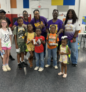 kids and adults gathered with backpacks and other new school supplies at community center event